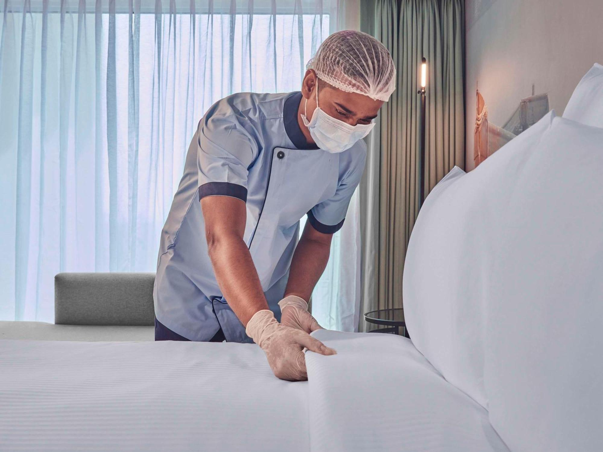 Novotel Mumbai International Airport Bombaim Exterior foto A hotel housekeeper making a bed