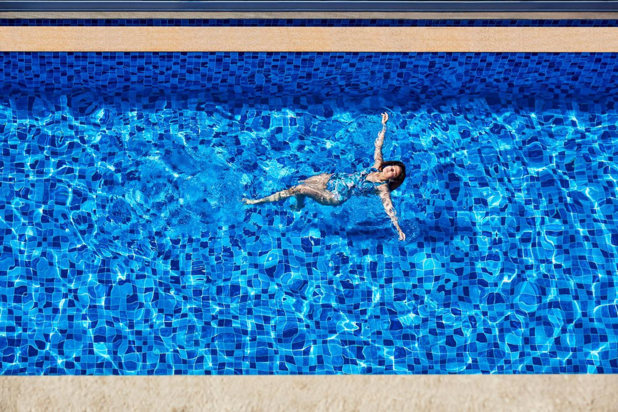Novotel Mumbai International Airport Bombaim Exterior foto A woman floating in a swimming pool