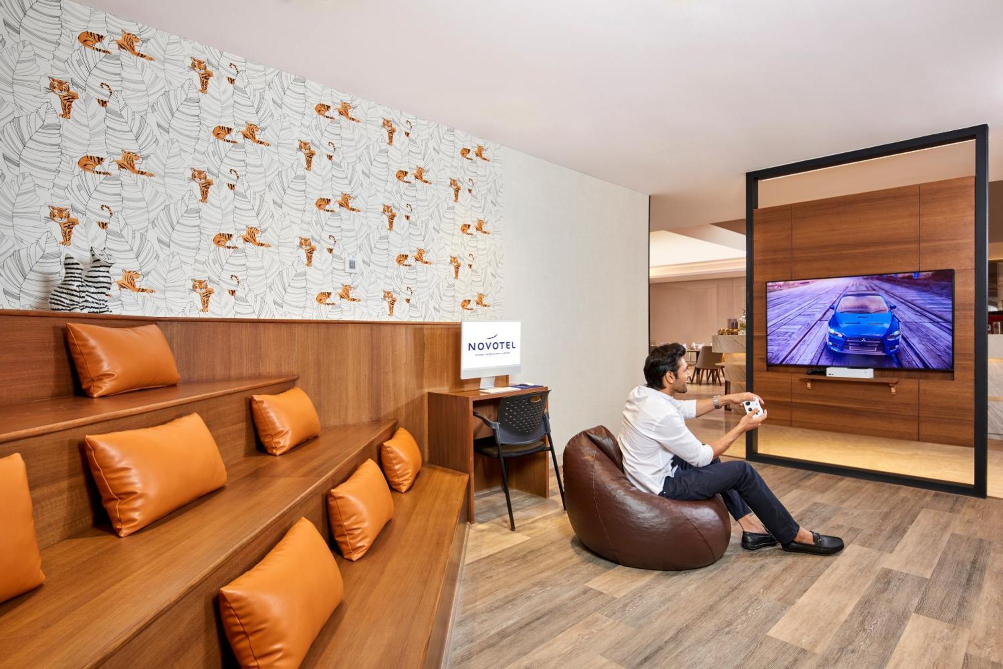 Novotel Mumbai International Airport Bombaim Exterior foto A man playing a video game at the lounge