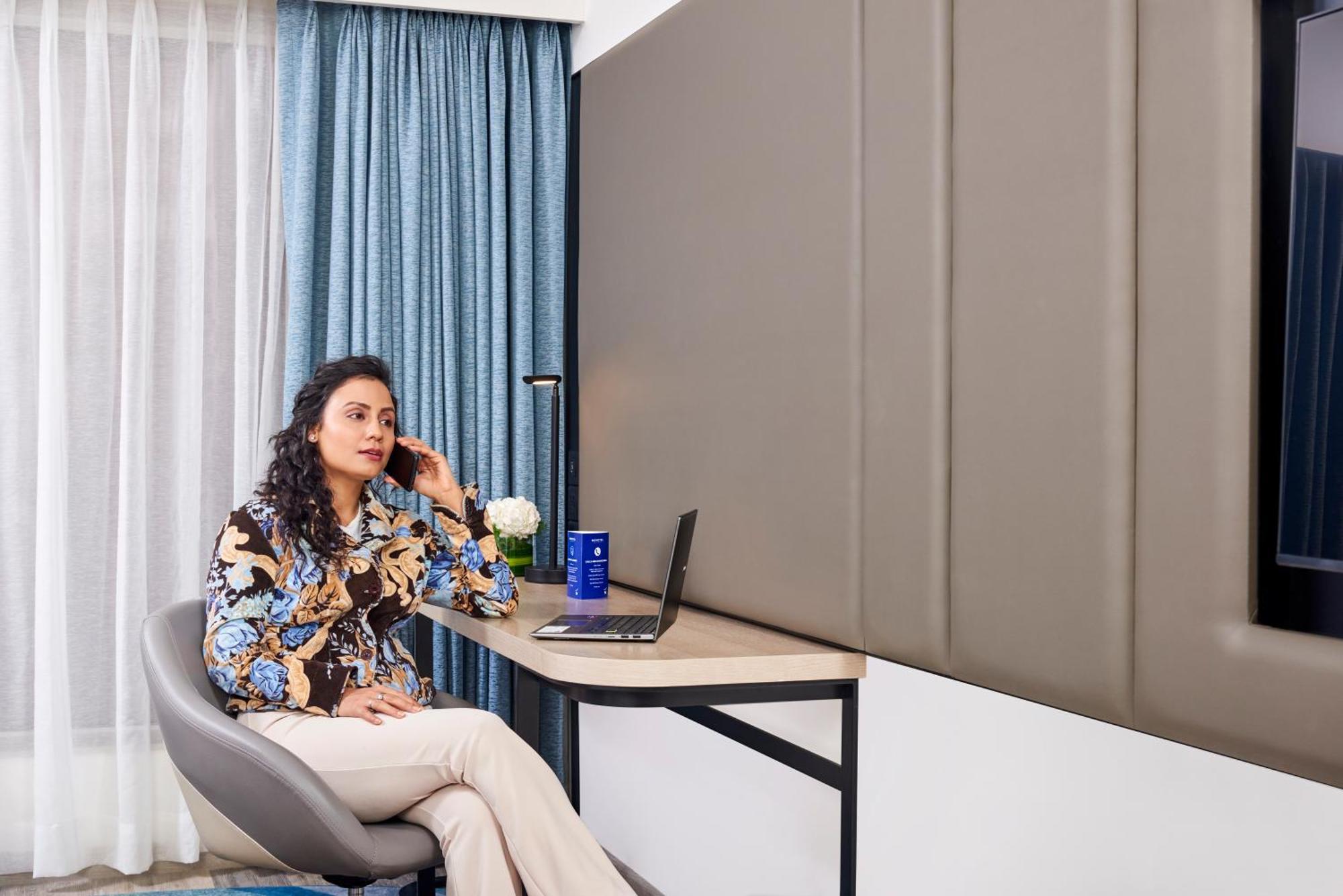 Novotel Mumbai International Airport Bombaim Exterior foto A woman working from home